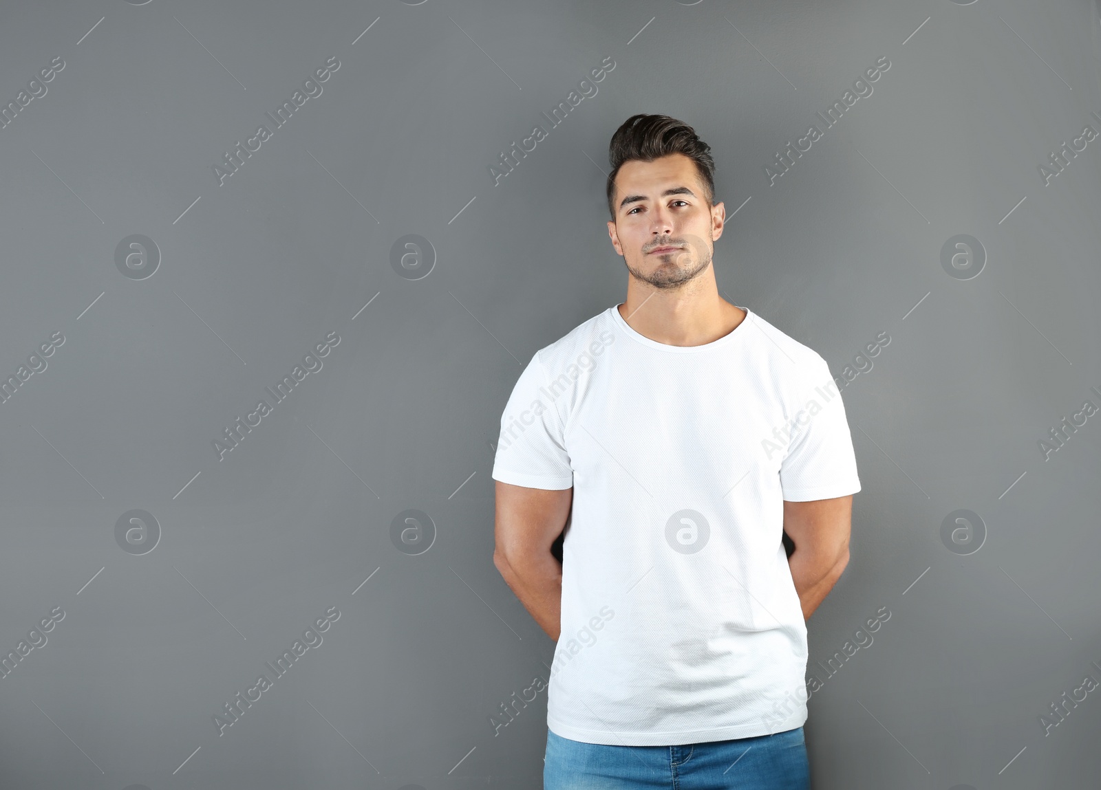 Photo of Young man in t-shirt on grey background. Mockup for design