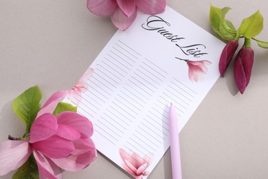 Guest list, pen and beautiful flowers on grey background, flat lay. Space for text