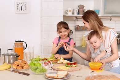 Photo of Housewife preparing dinner with her children on kitchen