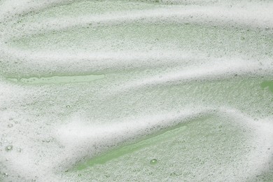 Photo of White washing foam on olive background, top view