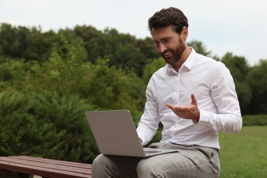 Photo of Handsome businessman with laptop on bench in park