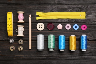 Photo of Flat lay composition with sewing threads and accessories on wooden background