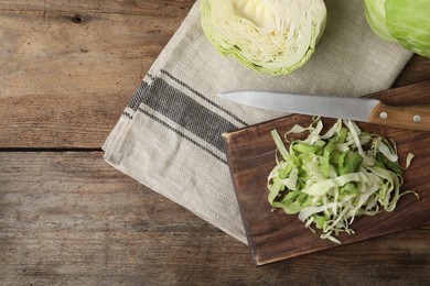 Photo of Chopped ripe cabbage on wooden table, flat lay