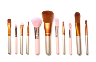 Photo of Flat lay composition with makeup brushes of professional artist on white background