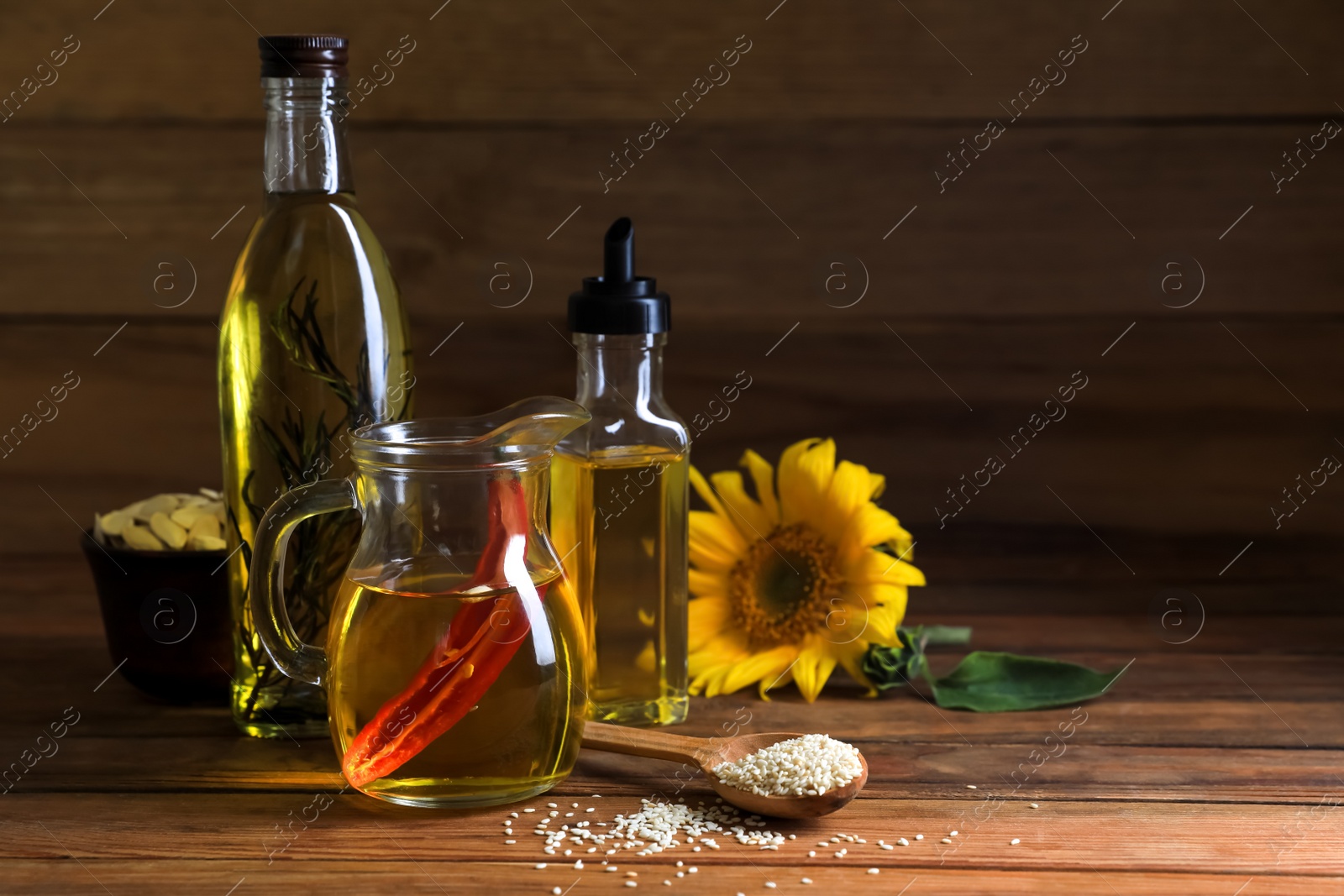 Photo of Different cooking oils and ingredients on wooden table. Space for text