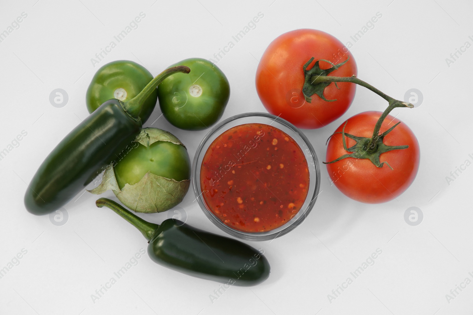 Photo of Bowl with delicious salsa sauce and ingredients on white background, flat lay