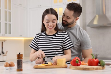 Lovely young couple cooking together in kitchen