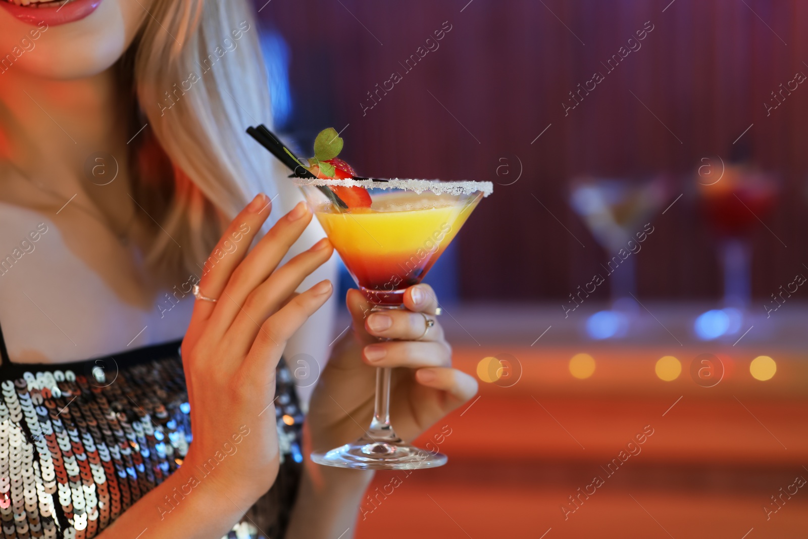 Photo of Young woman with glass of martini cocktail in bar, closeup. Space for text