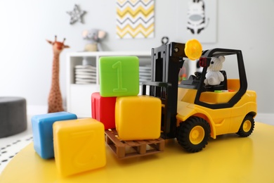 Photo of Toy stacker and cubes on table in child's room, closeup