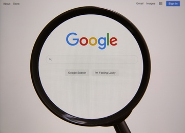 Photo of MYKOLAIV, UKRAINE - OCTOBER 30, 2020: Looking through magnifying glass at screen with Google search bar