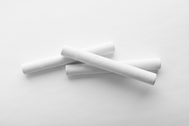 Pieces of chalk on white background, top view