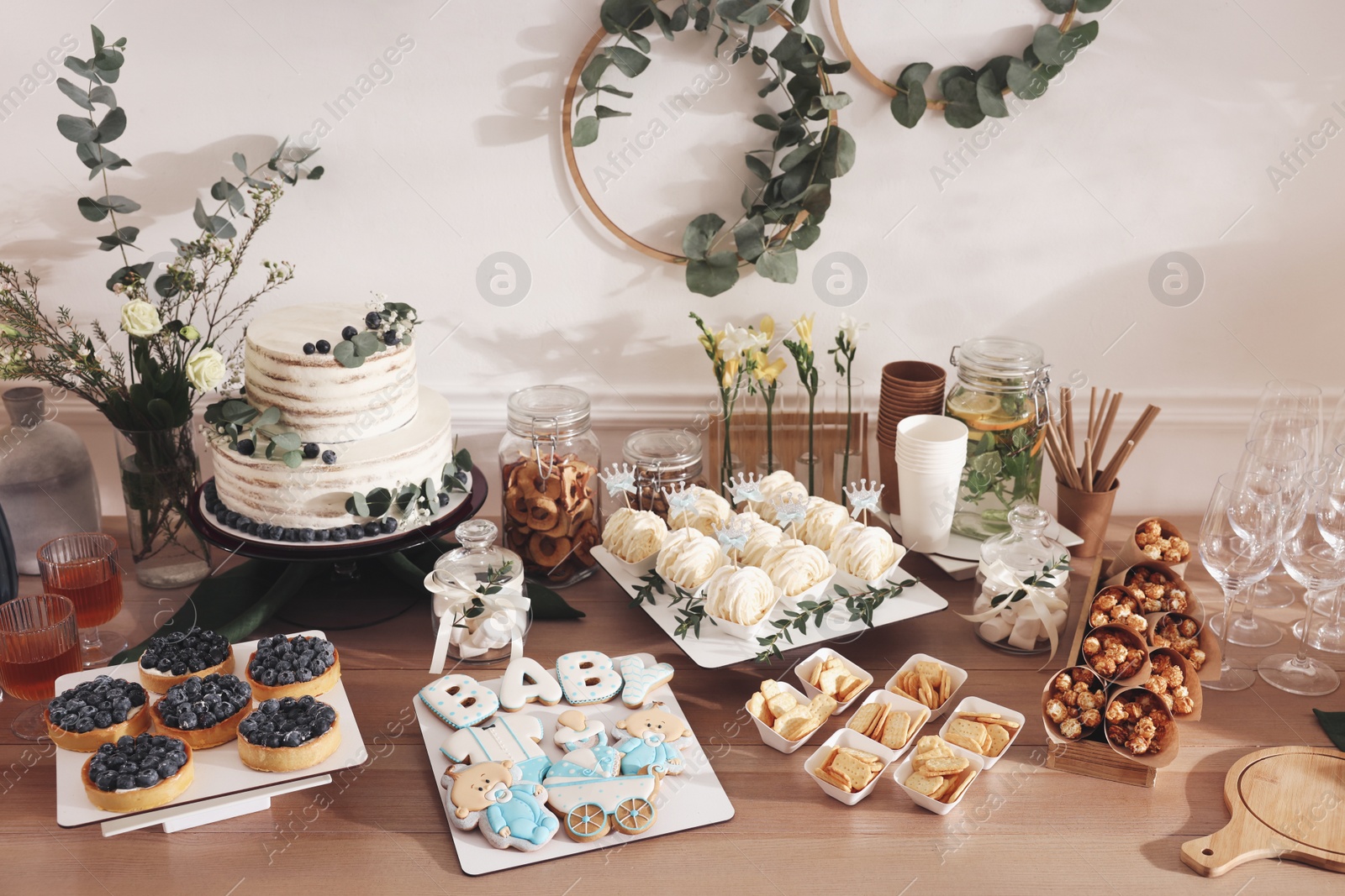 Photo of Beautiful cake and other treats on table in room. Baby shower party