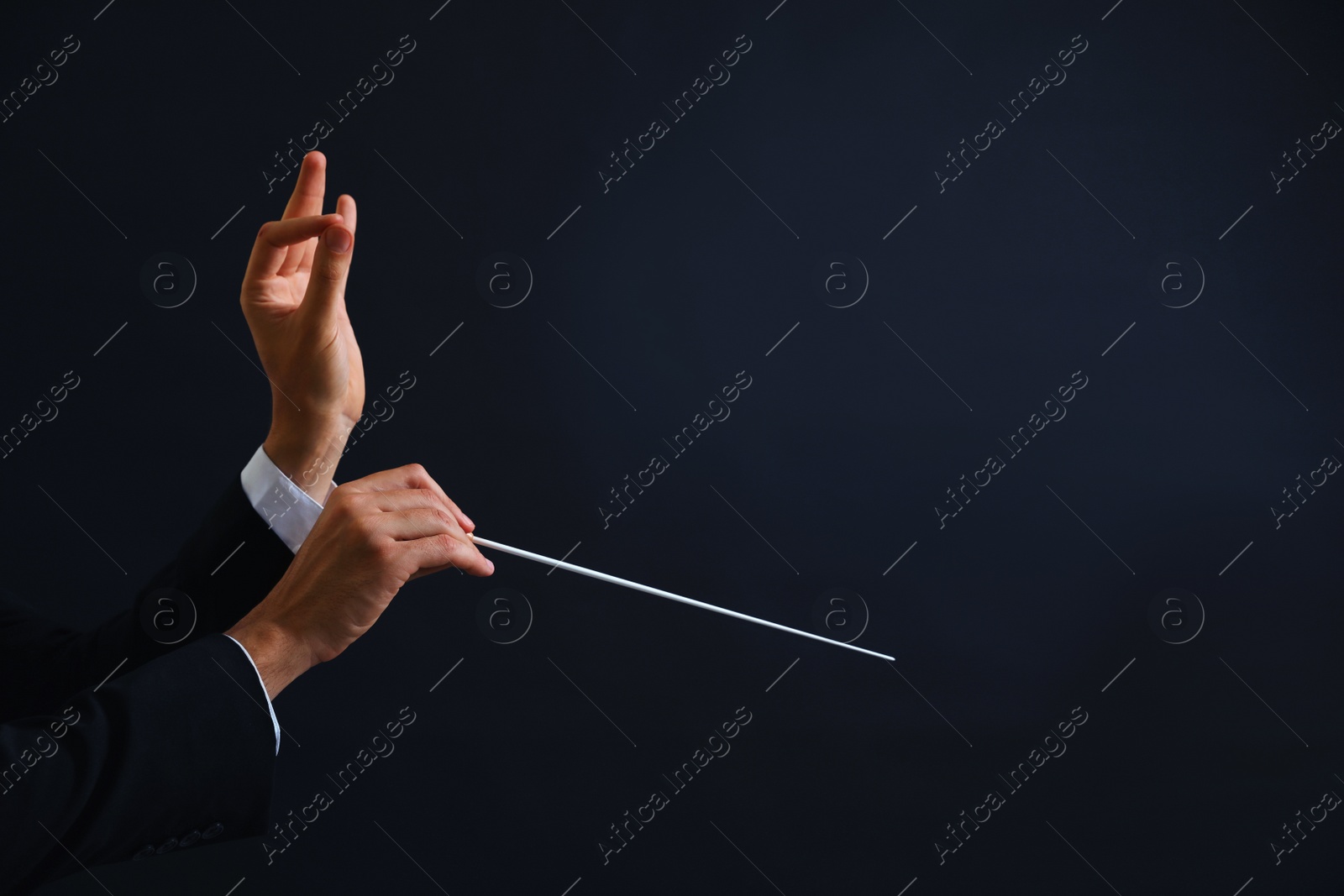 Photo of Professional conductor with baton on black background, closeup. Space for text