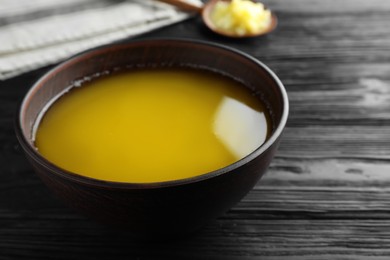 Photo of Bowl of Ghee butter on dark wooden table, closeup