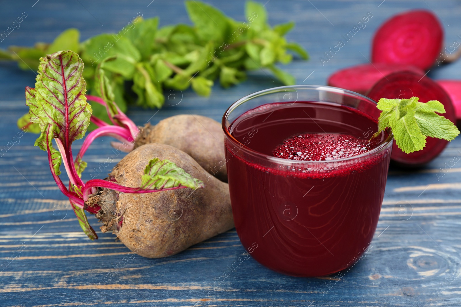 Photo of Freshly made beet juice on blue wooden table