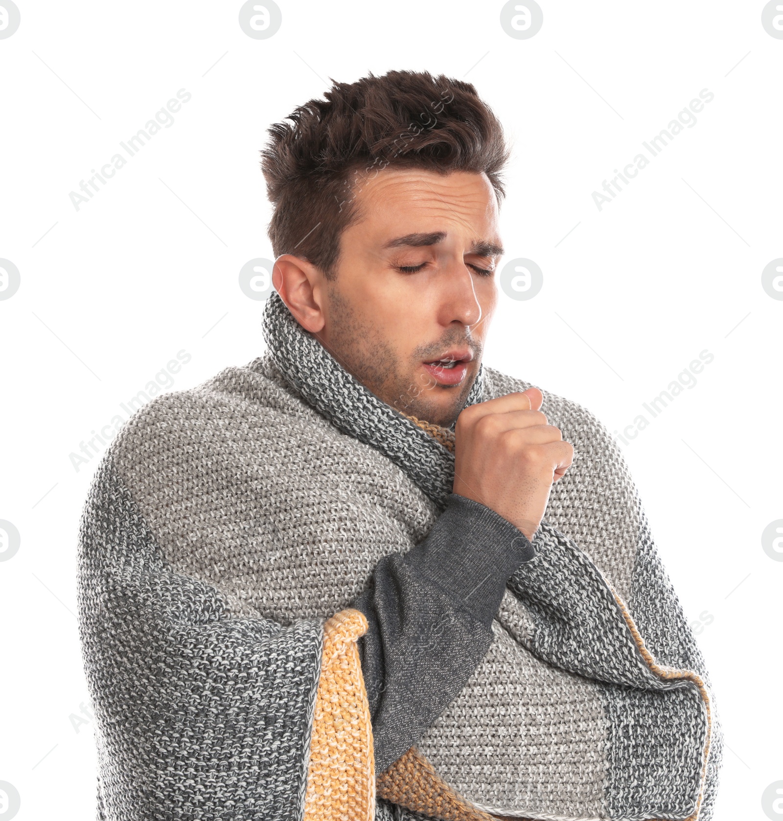 Photo of Young man wrapped in warm blanket suffering from cold on white background