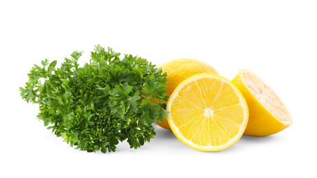 Photo of Green fresh parsley with lemons on white background