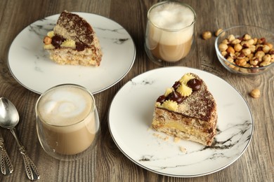 Pieces of delicious Kyiv Cake served with coffee on wooden table