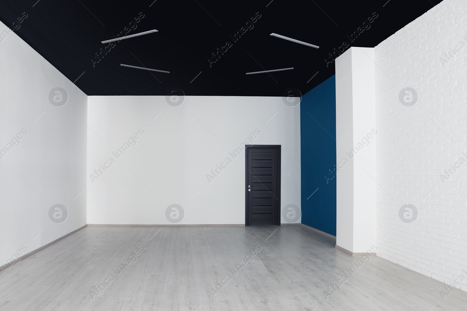 Photo of Empty office room with black ceiling and door. Interior design