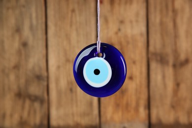 Photo of Evil eye amulet hanging near wooden wall