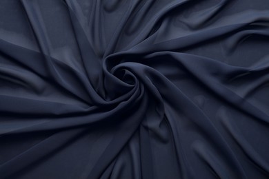 Photo of Beautiful dark blue tulle fabric as background, top view