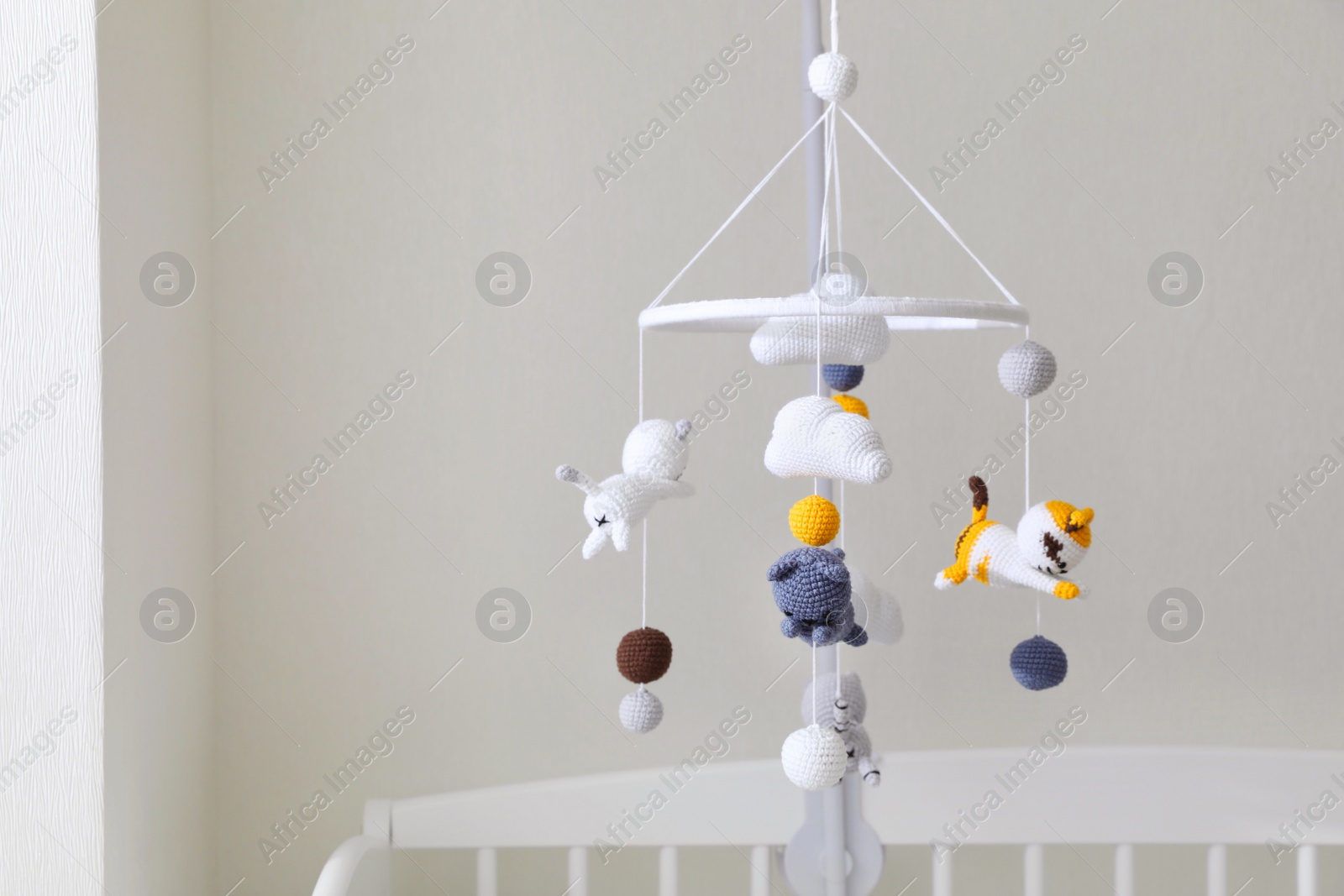 Photo of Modern baby mobile under crib in children's room