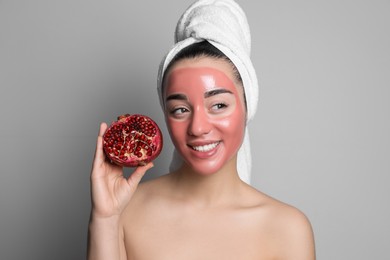 Photo of Woman with pomegranate face mask and fresh fruit on grey background