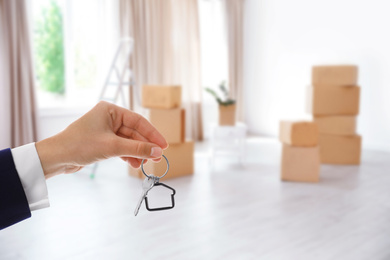 Image of Woman with key in new modern apartment, closeup