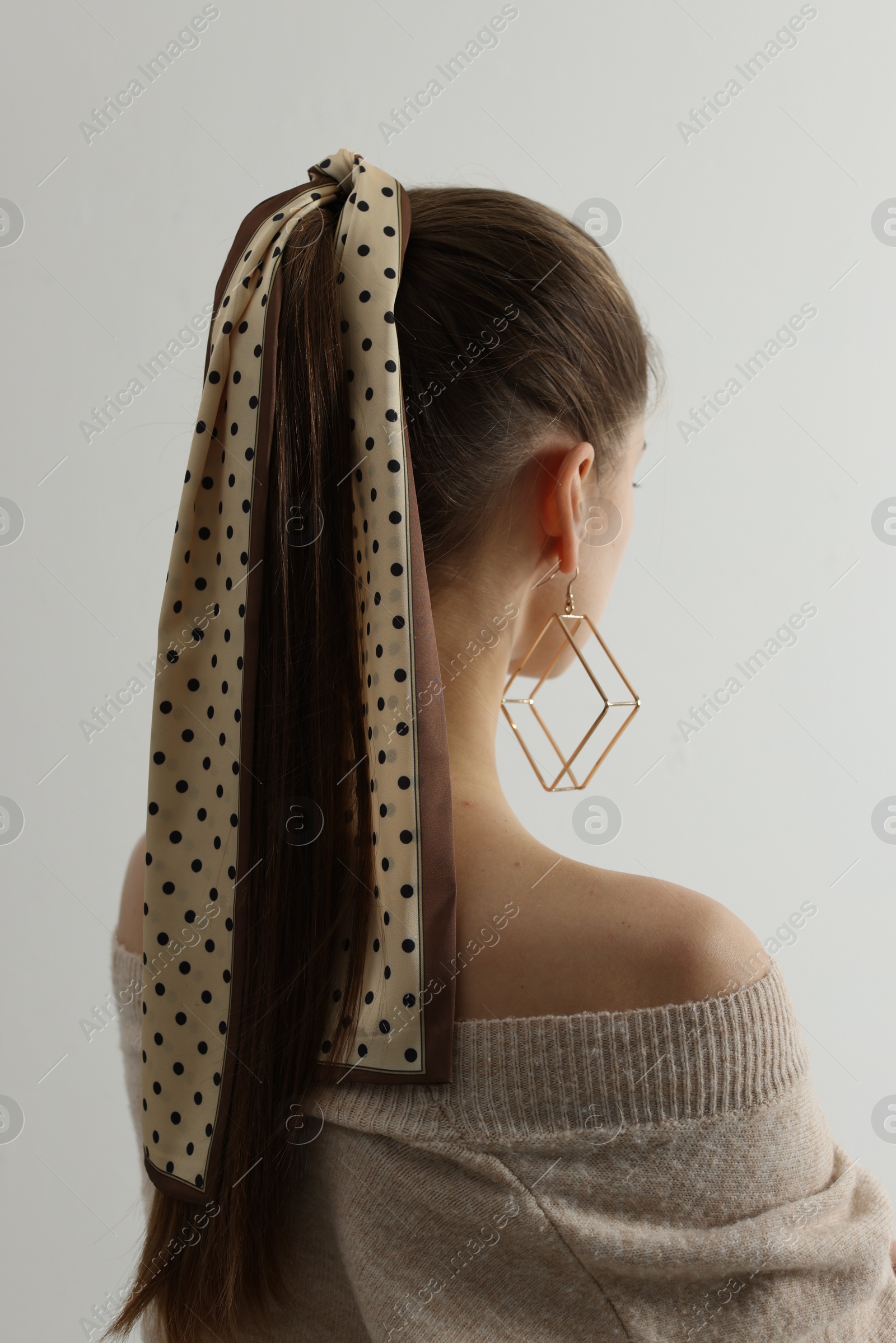 Photo of Young woman with stylish bandana on light background