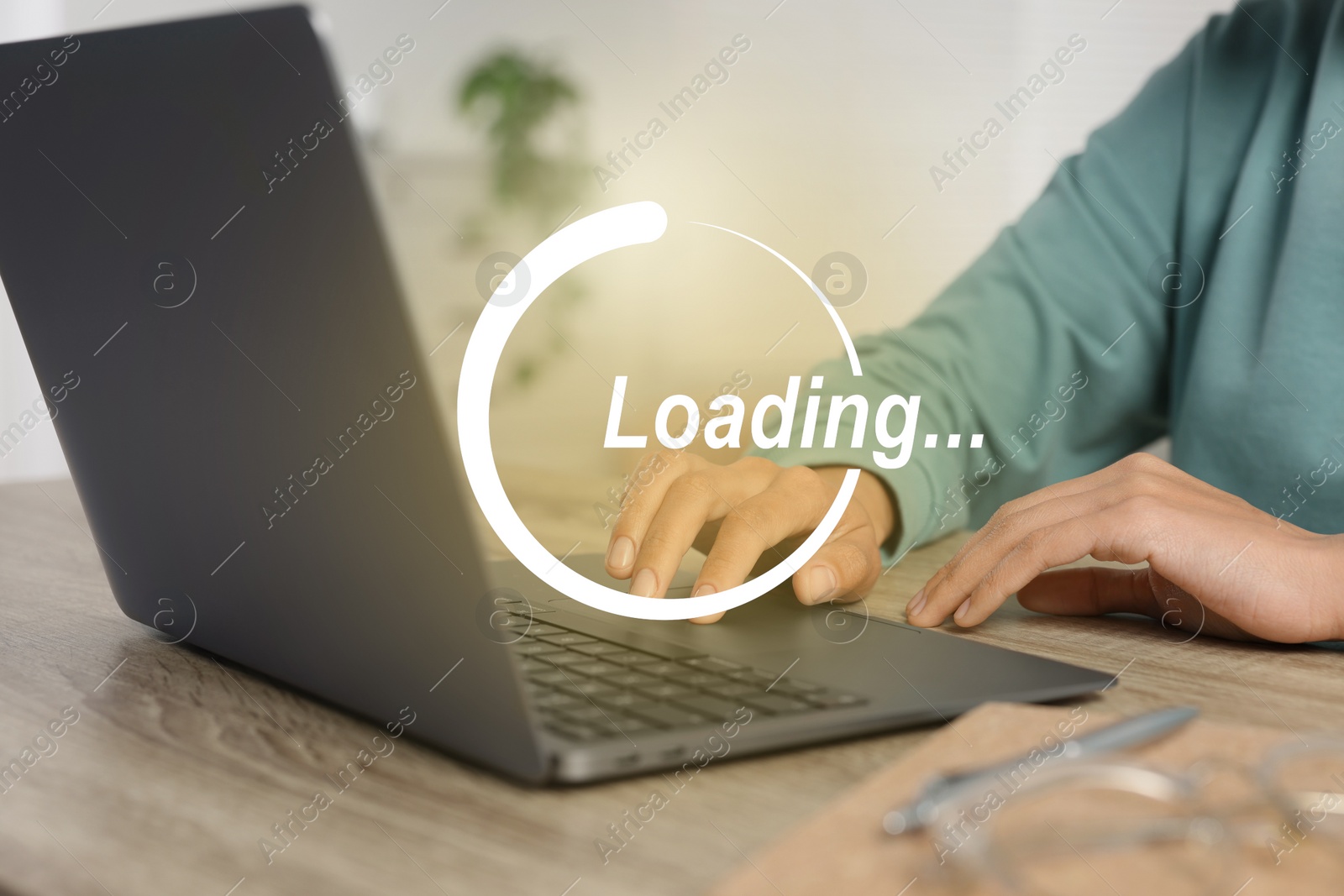 Image of Loading. Woman working on laptop at table indoors, closeup