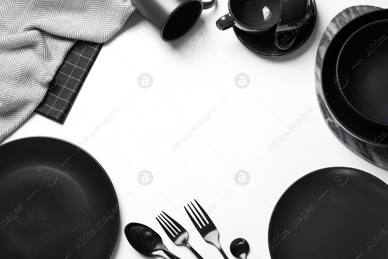 Photo of Frame made of black tableware on white background, flat lay. Space for text