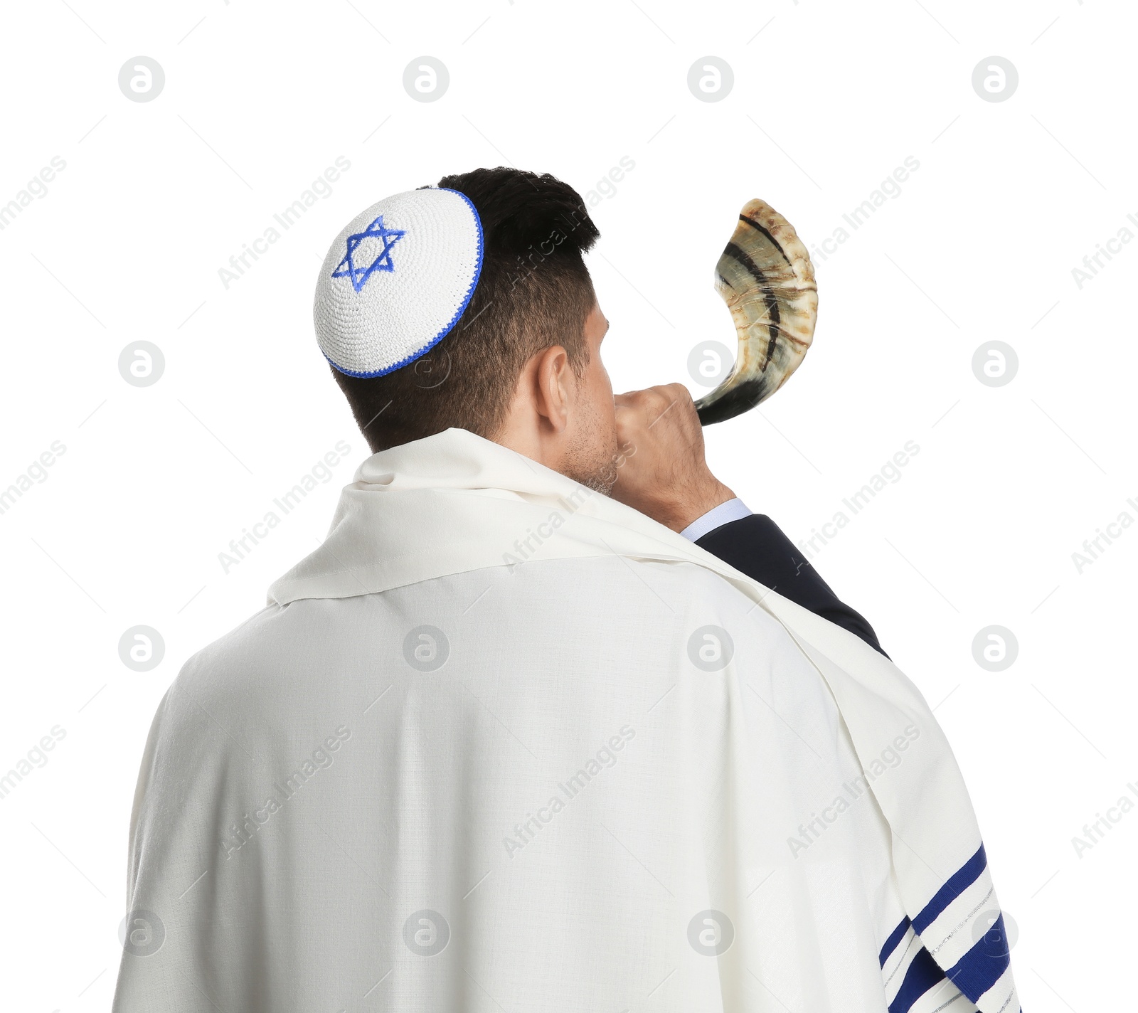 Photo of Jewish man with kippah and tallit blowing shofar on white background. Rosh Hashanah celebration