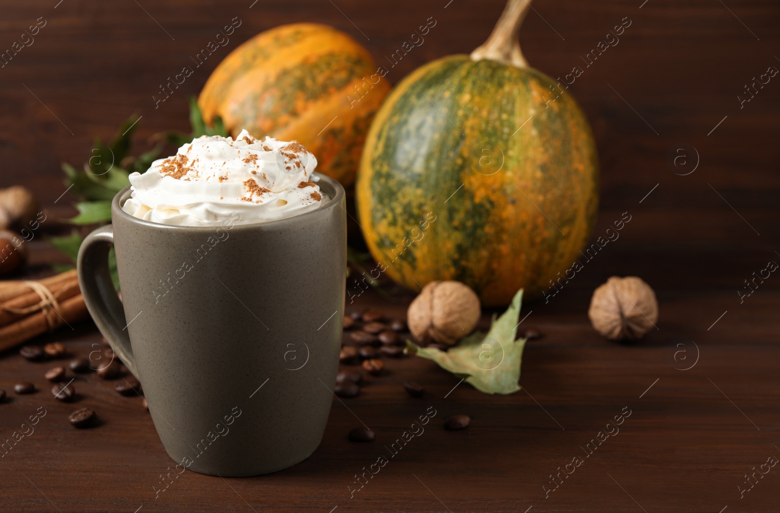 Photo of Cup with tasty pumpkin spice latte on wooden table