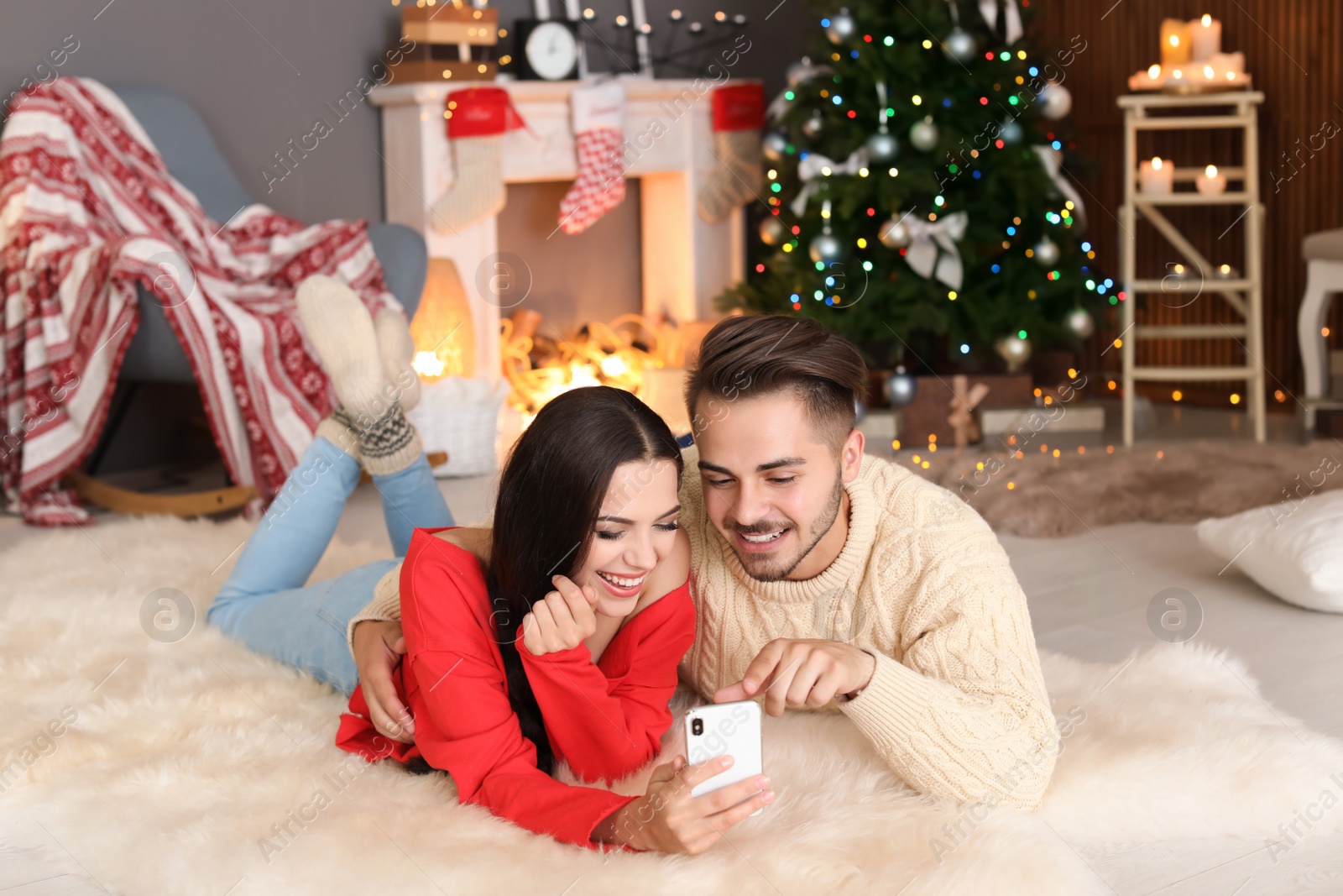 Photo of Happy young couple taking selfie in decorated for Christmas room