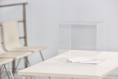 Photo of Ballot box on table at polling station. Space for text