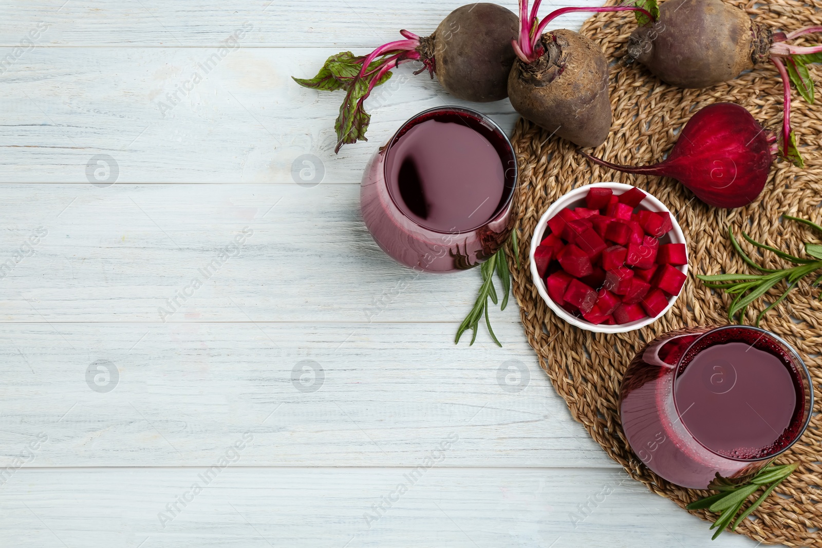 Photo of Fresh beet juice and raw vegetable on white wooden table, flat lay. Space for text