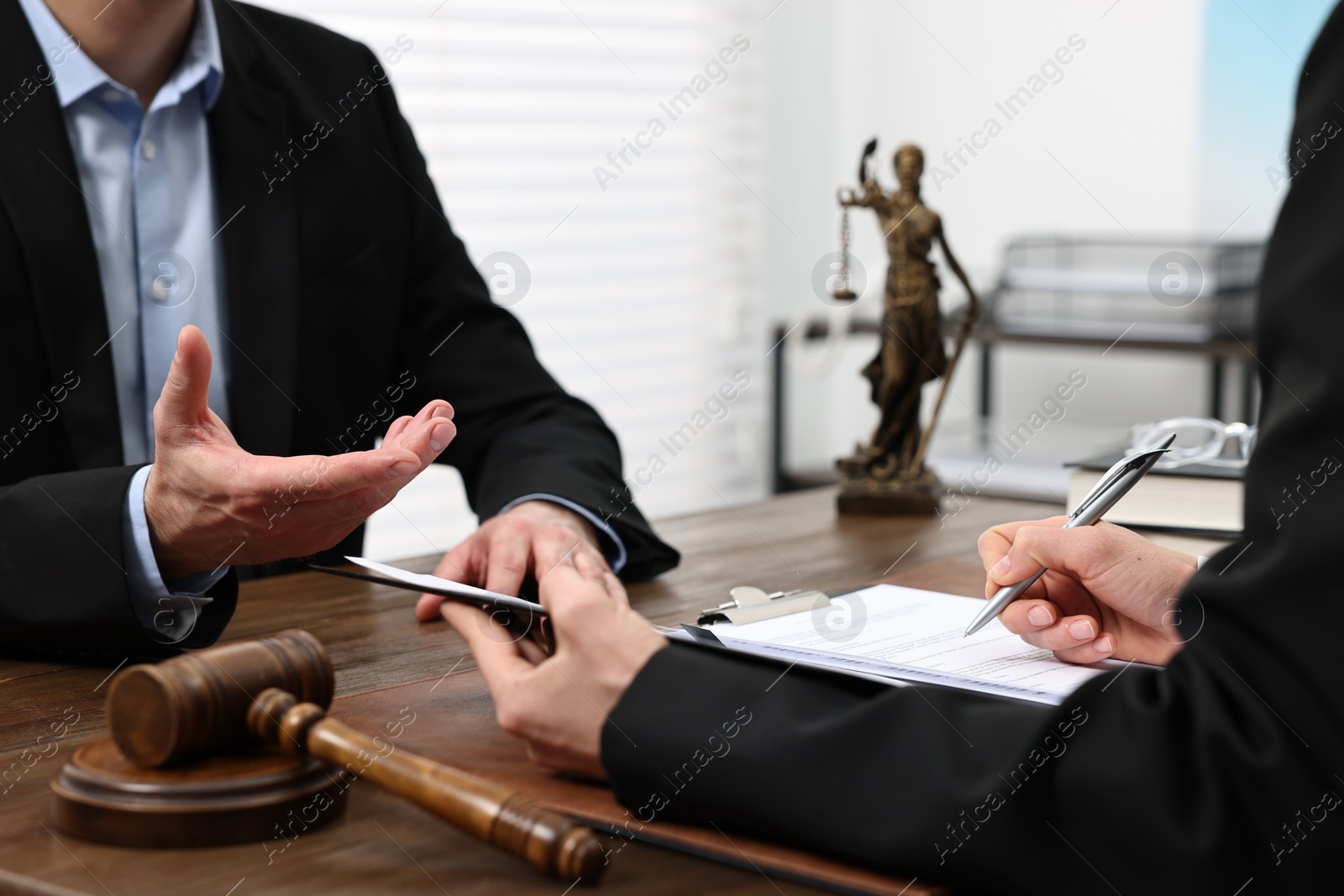 Photo of Woman signing document in lawyer's office, closeup