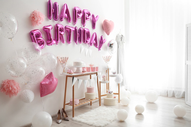 Phrase HAPPY BIRTHDAY made of pink balloon letters in decorated room