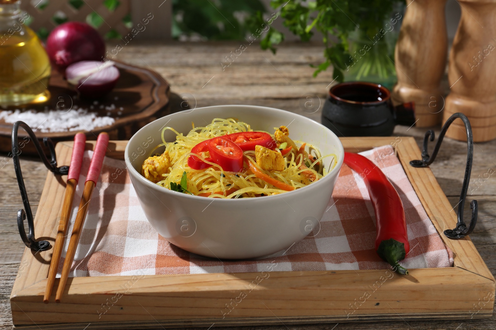 Photo of Stir-fry. Tasty noodles with vegetables and meat in bowl served on wooden table