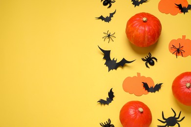 Flat lay composition with paper bats, pumpkins and spiders on yellow background, space for text. Halloween decor