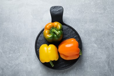 Photo of Fresh ripe bell peppers on grey table, top view