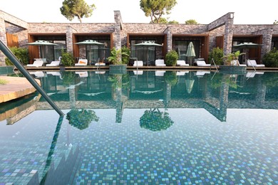 Photo of Outdoor swimming pool with wooden deck and sunbeds at resort