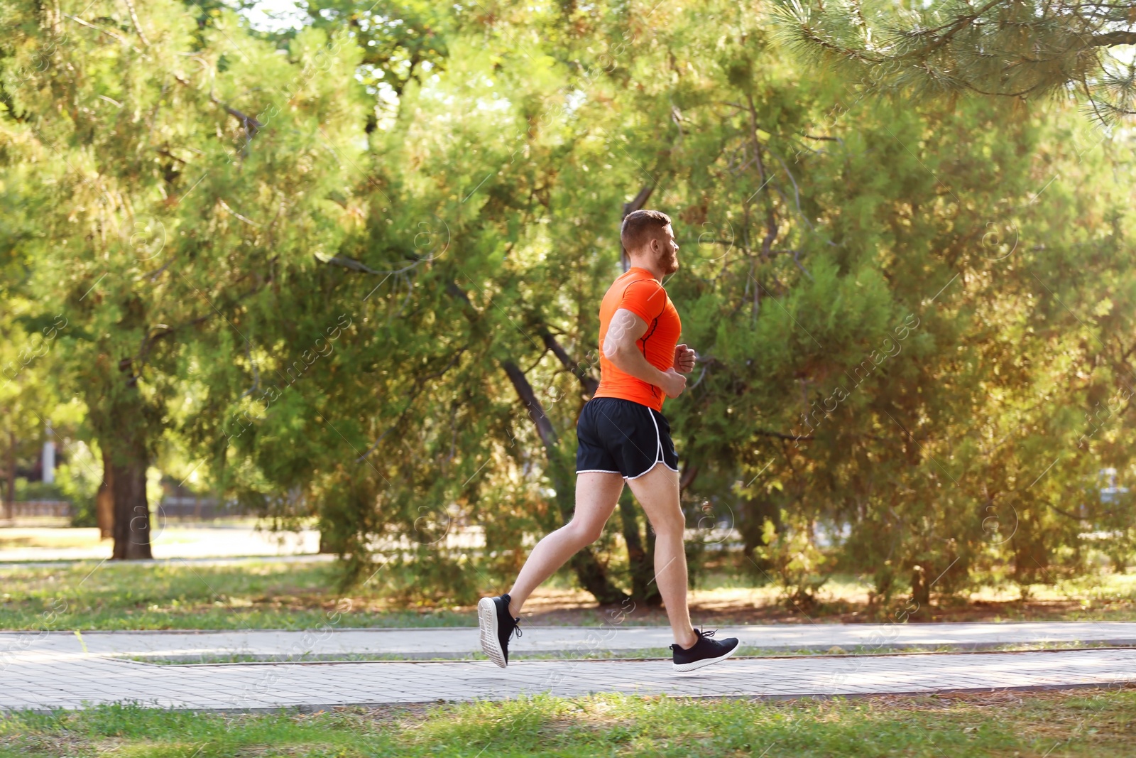 Photo of Young man running in park on sunny day