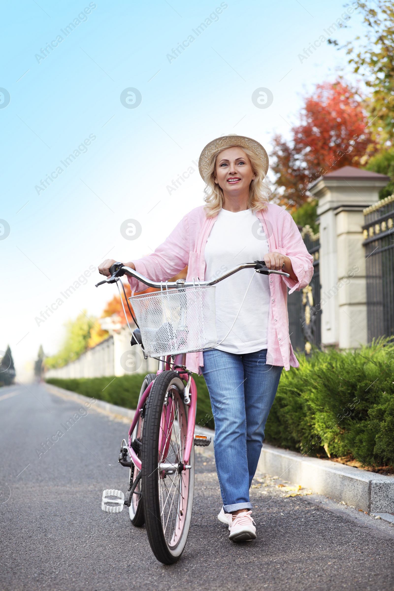 Photo of Mature woman with bicycle outdoors. Active lifestyle