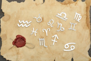 Photo of Zodiac signs and old paper on grey table, flat lay