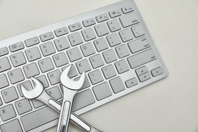 Photo of Wrenches and computer keyboard on light background. Concept of technical support