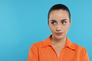 Photo of Portrait of resentful woman on light blue background. Space for text