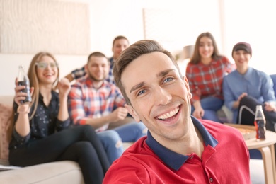 Happy friends taking selfie indoors