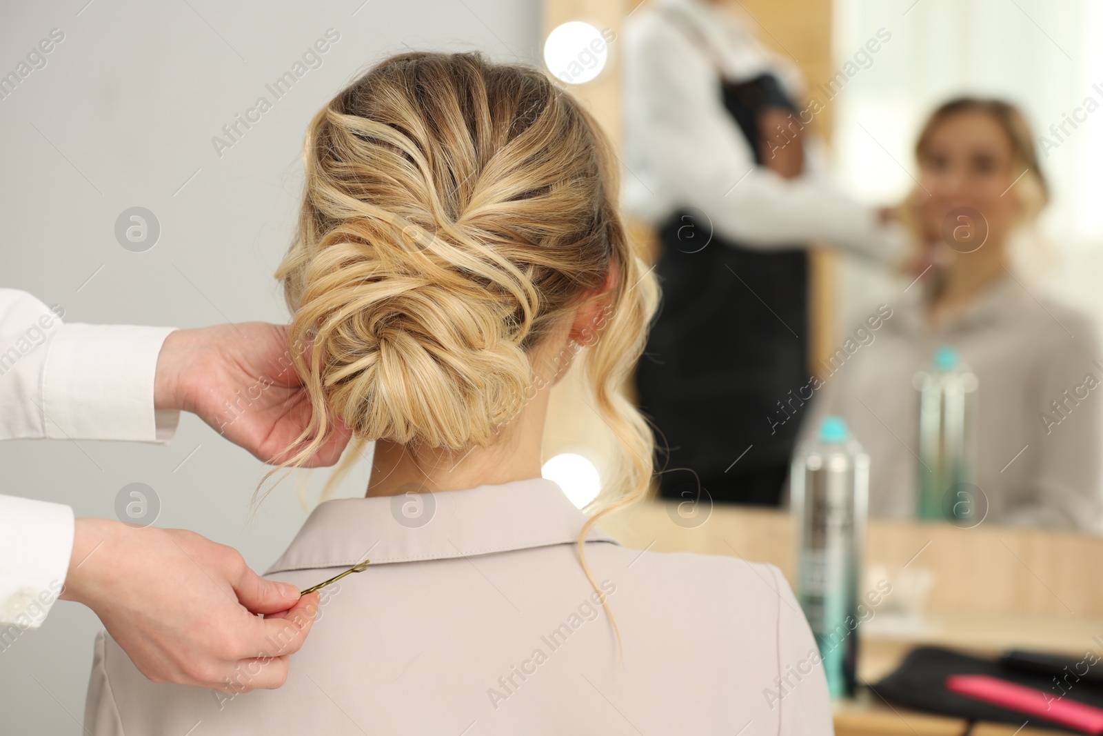 Photo of Hair styling. Professional hairdresser working with client indoors, closeup