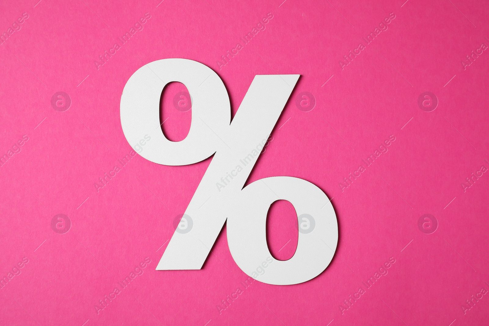 Photo of White percent sign on pink background, top view